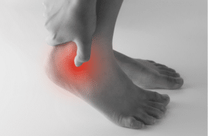 Achilles tendon by hands, suffering with pain in red spot area
