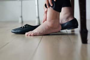 Elderly woman swollen feet putting on shoes